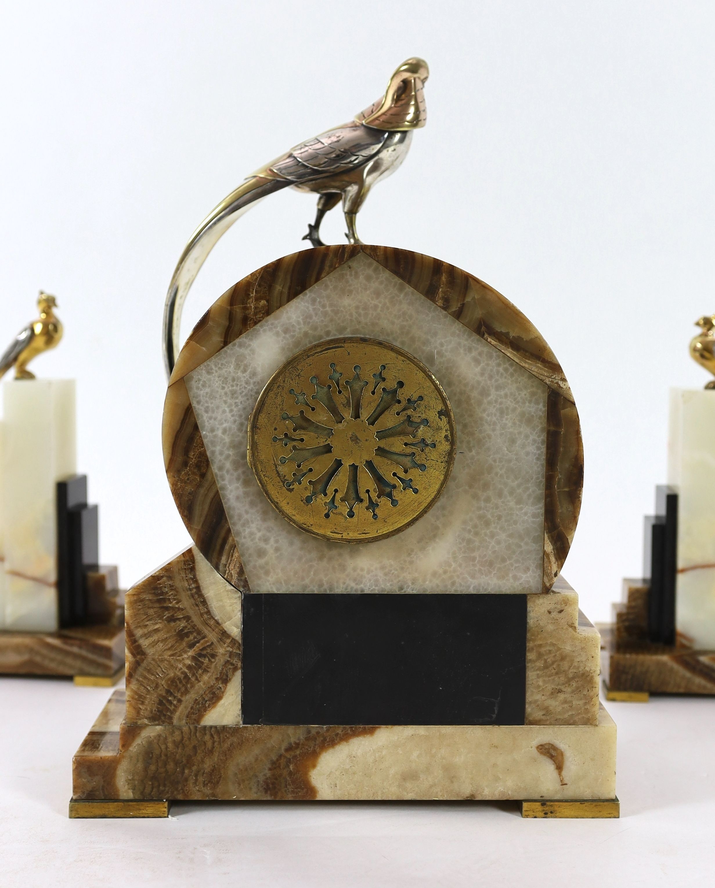 F.H. Danvin. A 1930's French Art Deco bronze mounted onyx and marble clock garniture, clock: width 32cm, height 46cm, side ornaments: width 15cm, height 31cm